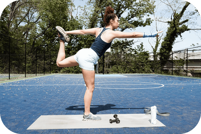 Woman wearing a 3D printed cast on her wrist doing yoga on a basketball court